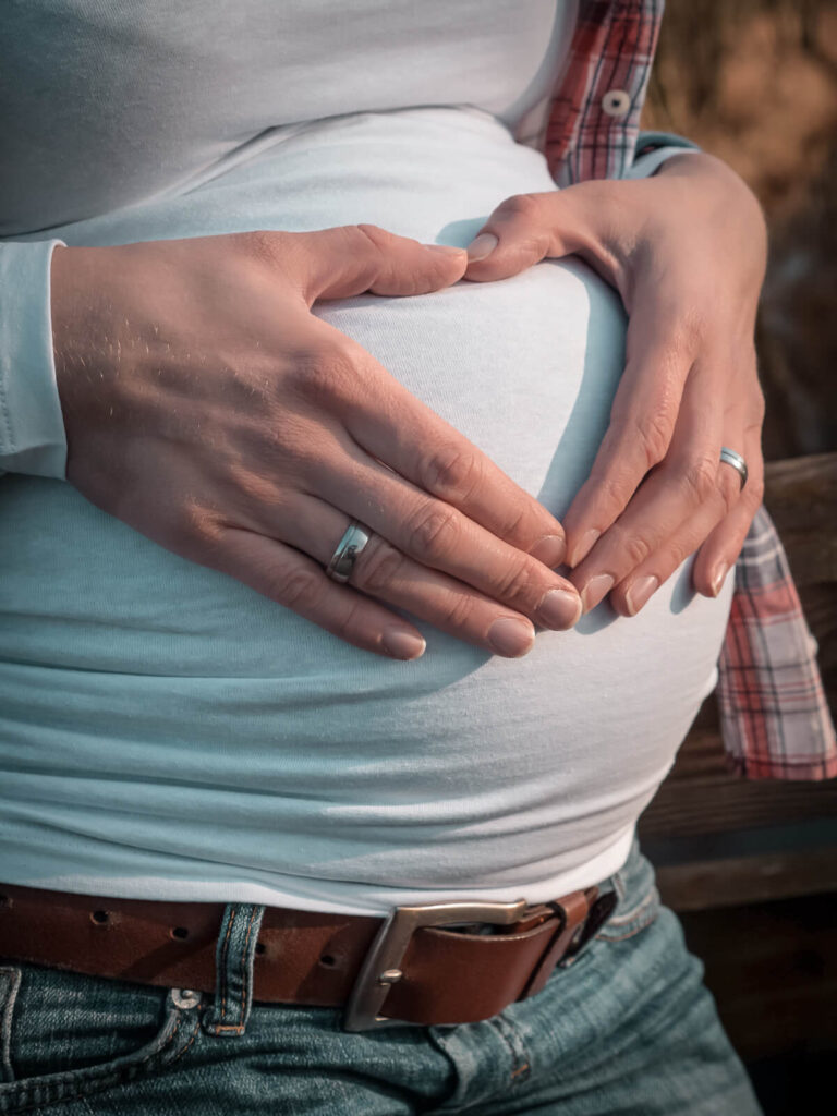 Babybauchfotografie Hankensbüttel - eine Frau legt ihre Hände als Herz auf ihren Babybauch