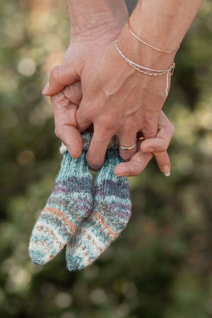 Babybauchshooting Hankensbüttel - Babysöckchen in den verschränkten Händen der Eltern