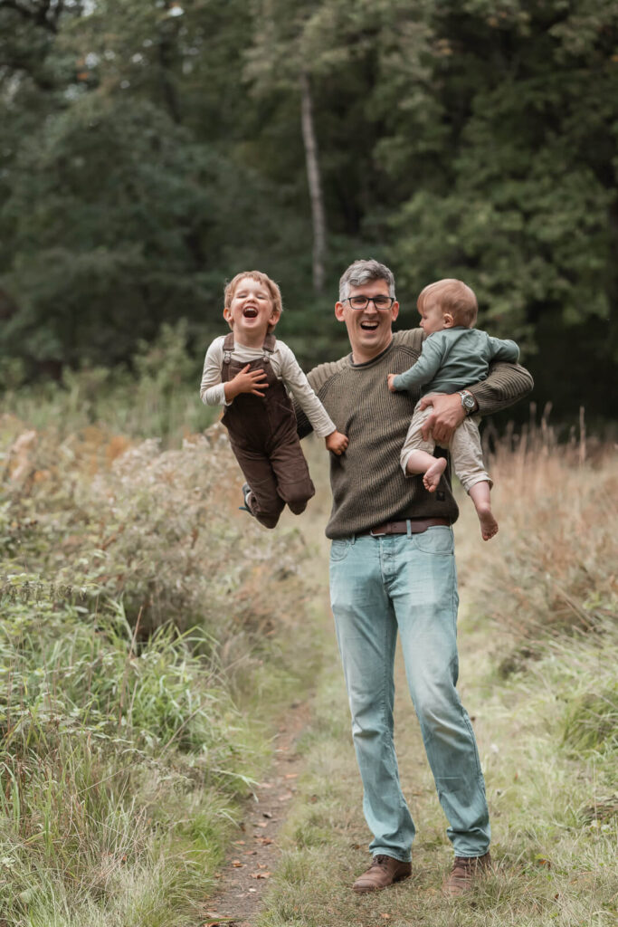Familielnfotos mit Spaß in Hankensbütte - Vaterj trägt lachend seine zwei Söhne