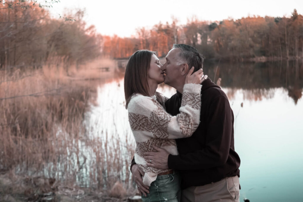 verliebter Moment der Nähe - ein Kuss am See im Abendlicht beim Paarshooting