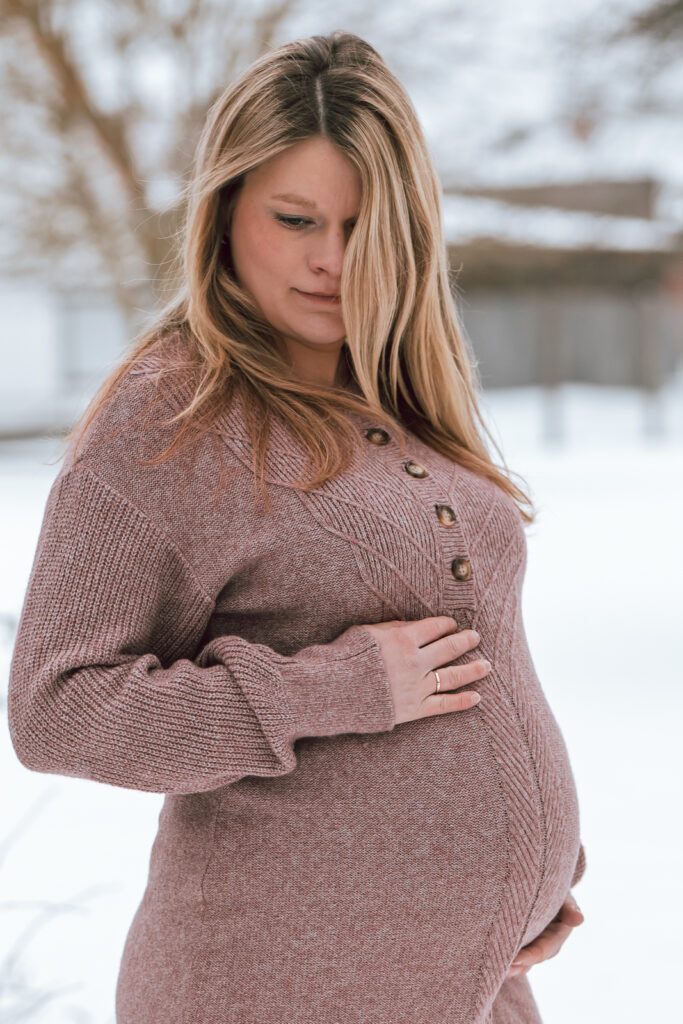 Babybauchshooting im Schnee - träumerische und nachdenkliche Mama