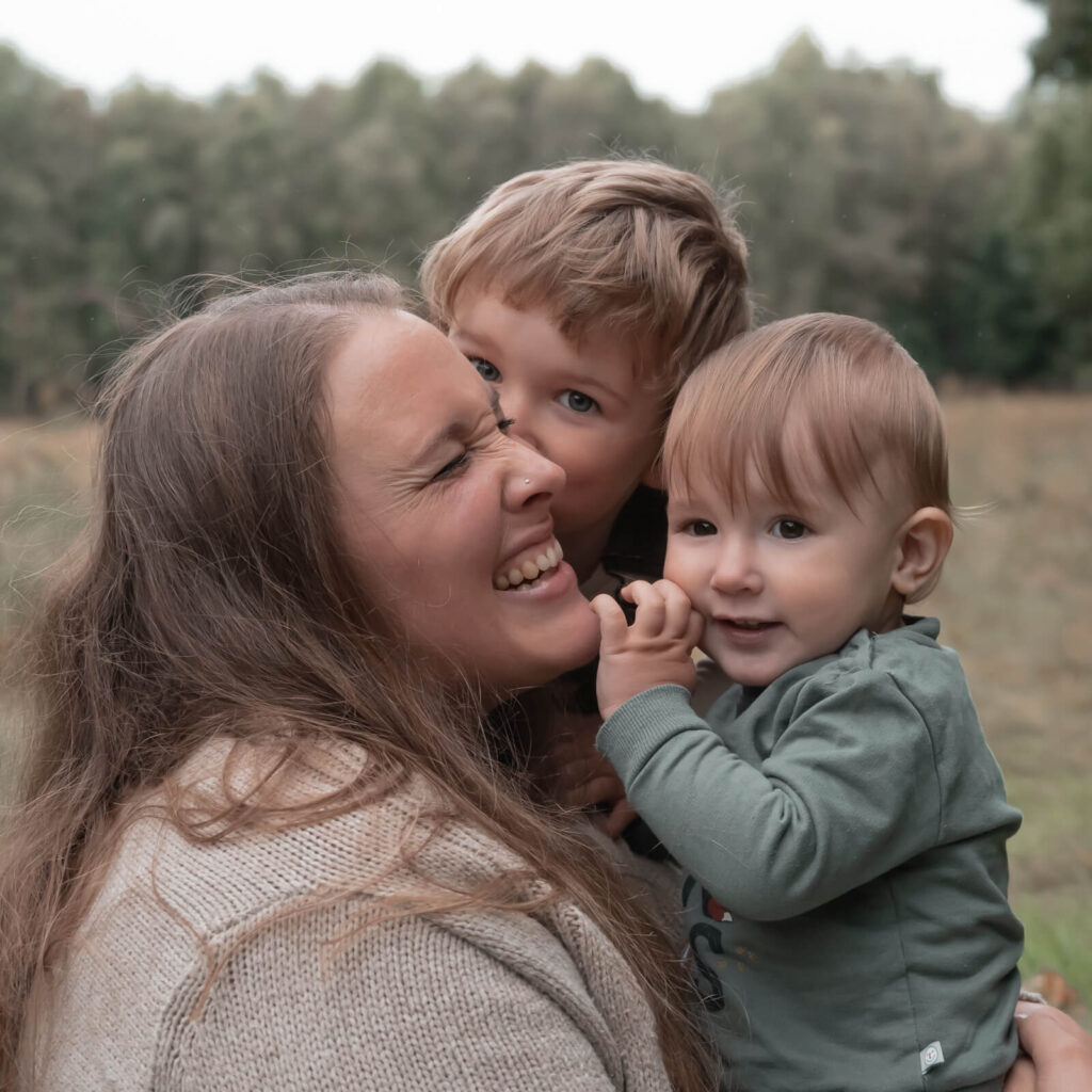 Foto von Mama und Kindern beim Schmusen während des Familienshootings