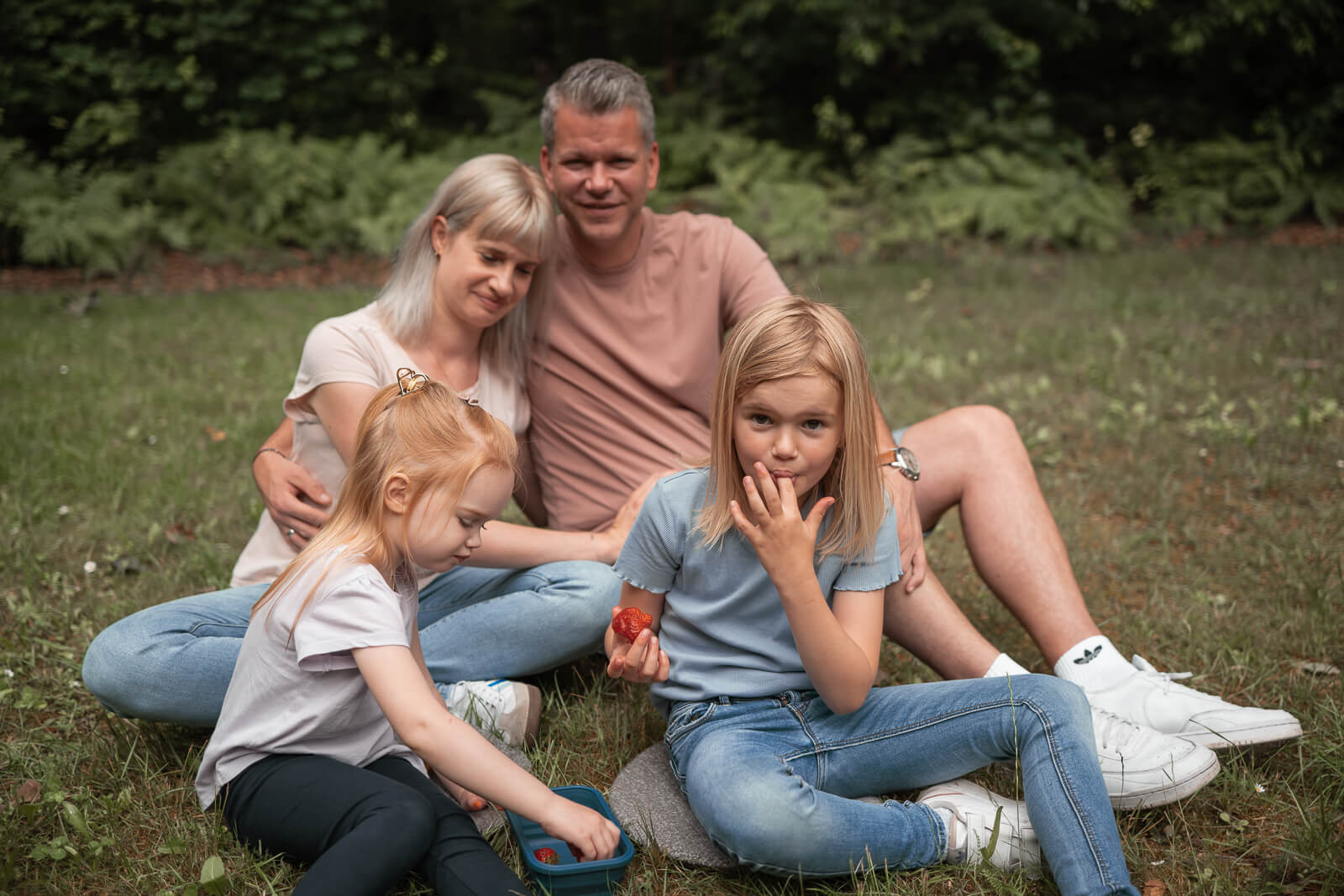 Foto einer Familie bei Picknick im Grünen mit Erdbeer-Nascherei
