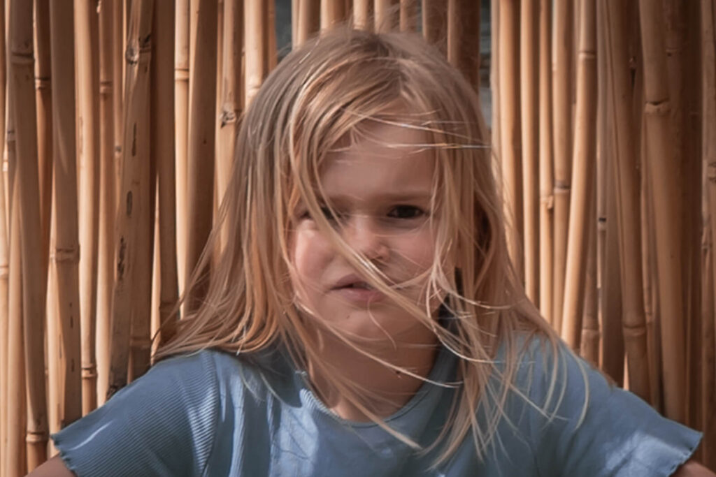 Beim Familienshooting - ein Portrait eines Mädchens mit wilden Haarstähnen im Gesicht