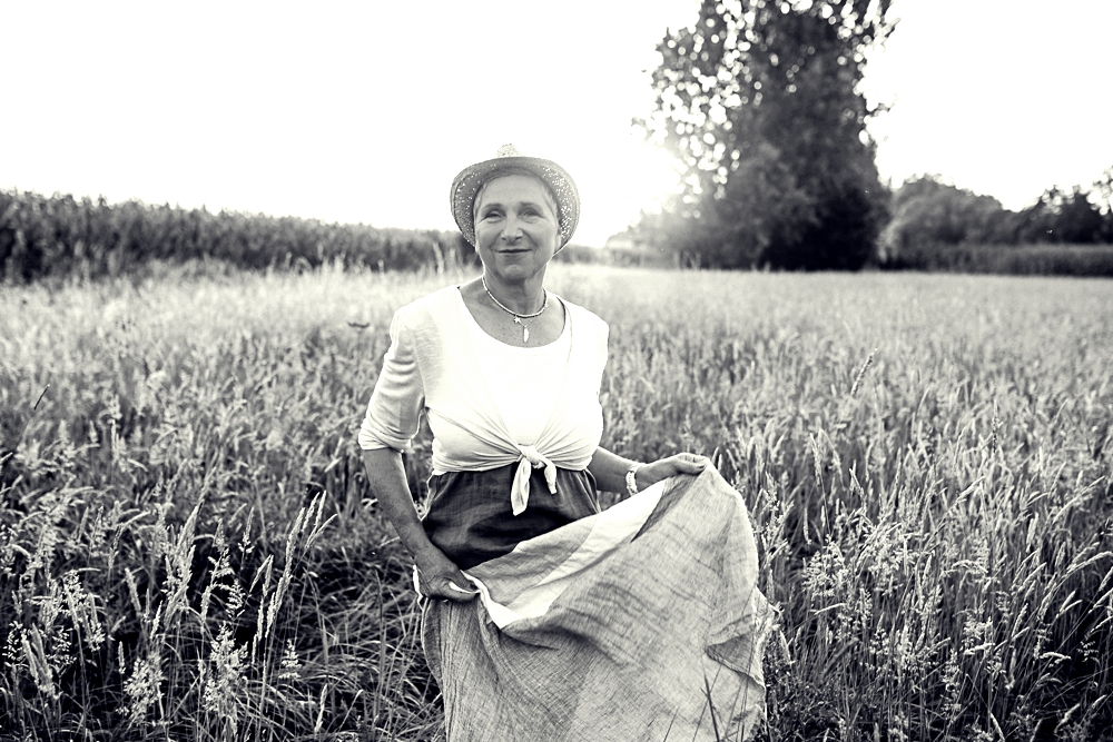 Fotografin Hankensbüttel unbeschwert im Sommerkleid auf einer ungemähten Wiese in schwarz-weiß