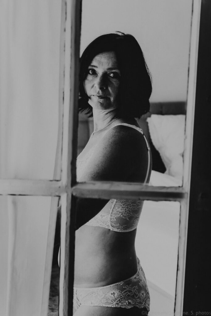 Sinnliches Foto einer Frau in Unterwäsche durch ein Fenster