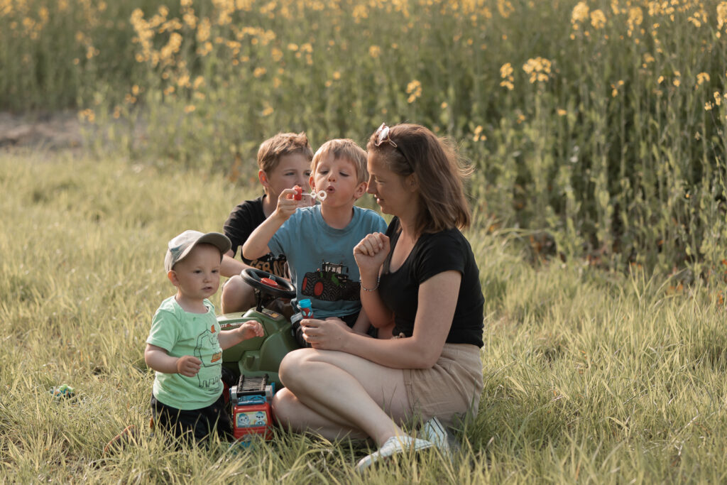 Foto einer Familie mit 3 Jungs im Mai am Rapsfeld