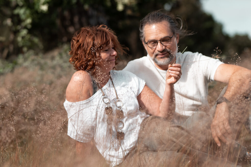 Foto eines turtelnden Paares im Gras sitzend